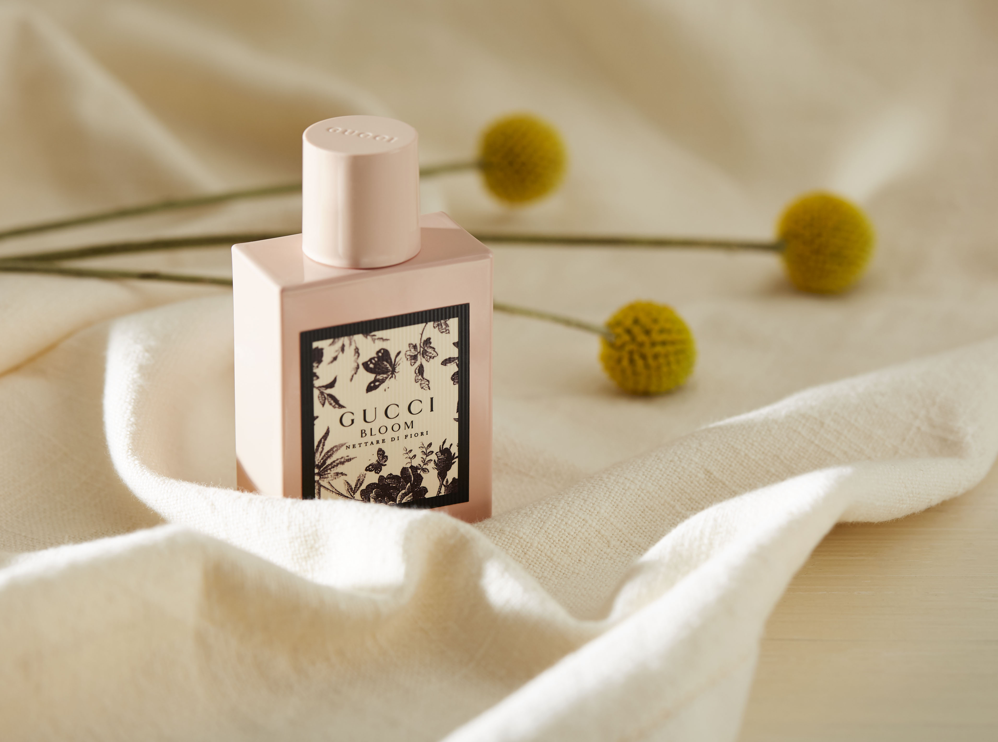 Foto del profumo Gucci Bloom con fiori e seta.