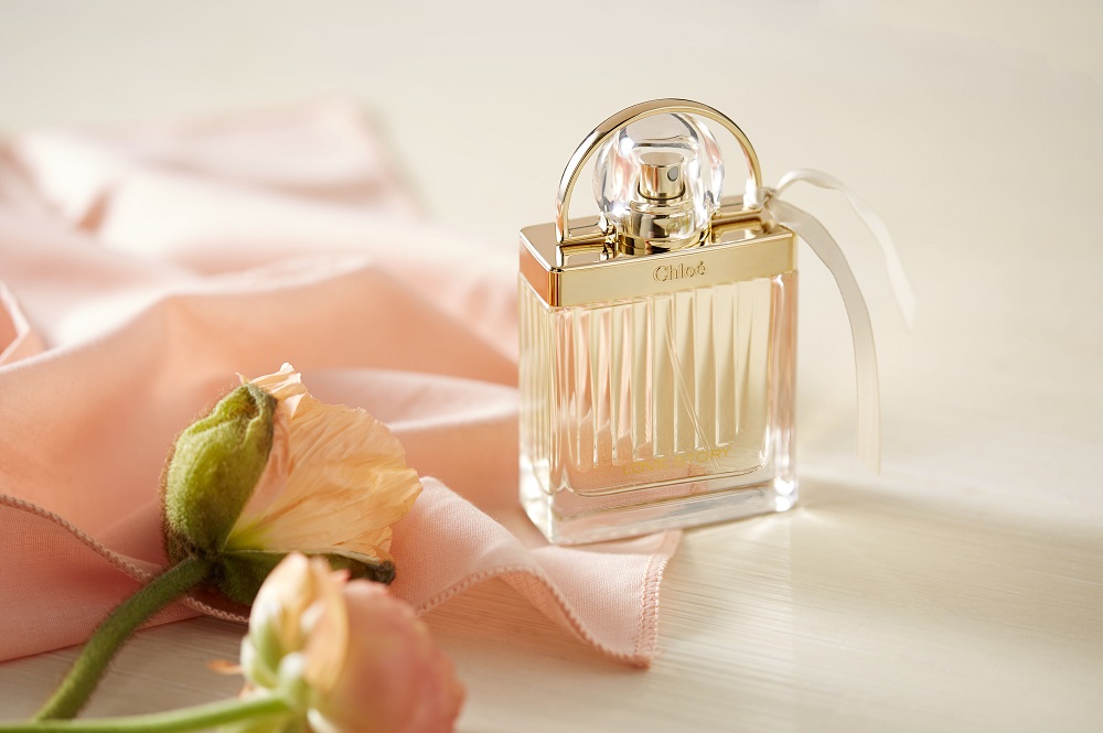 Foto del profumo Chloé Love Story con rose e seta rosa.