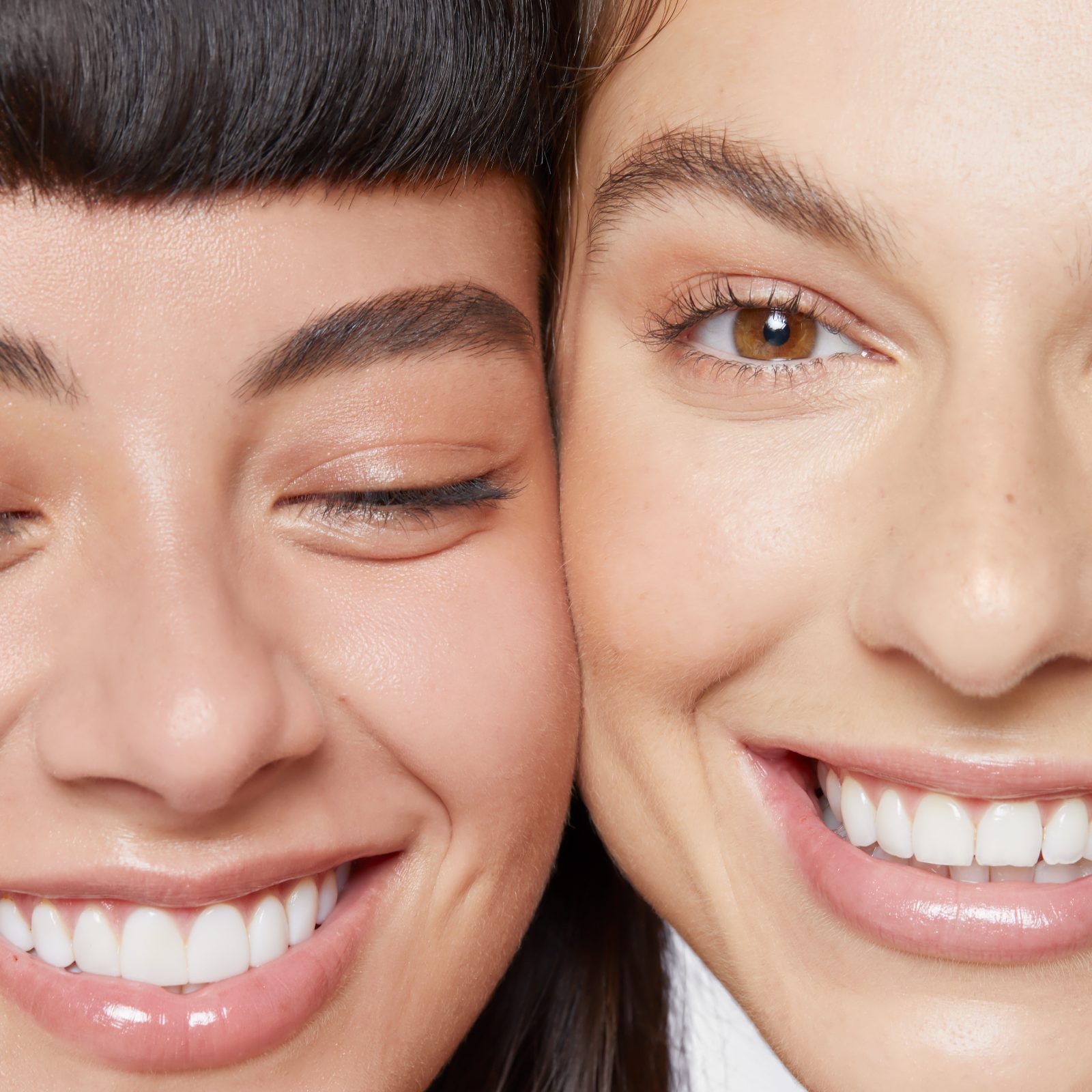 2 females with faces side by side laughing