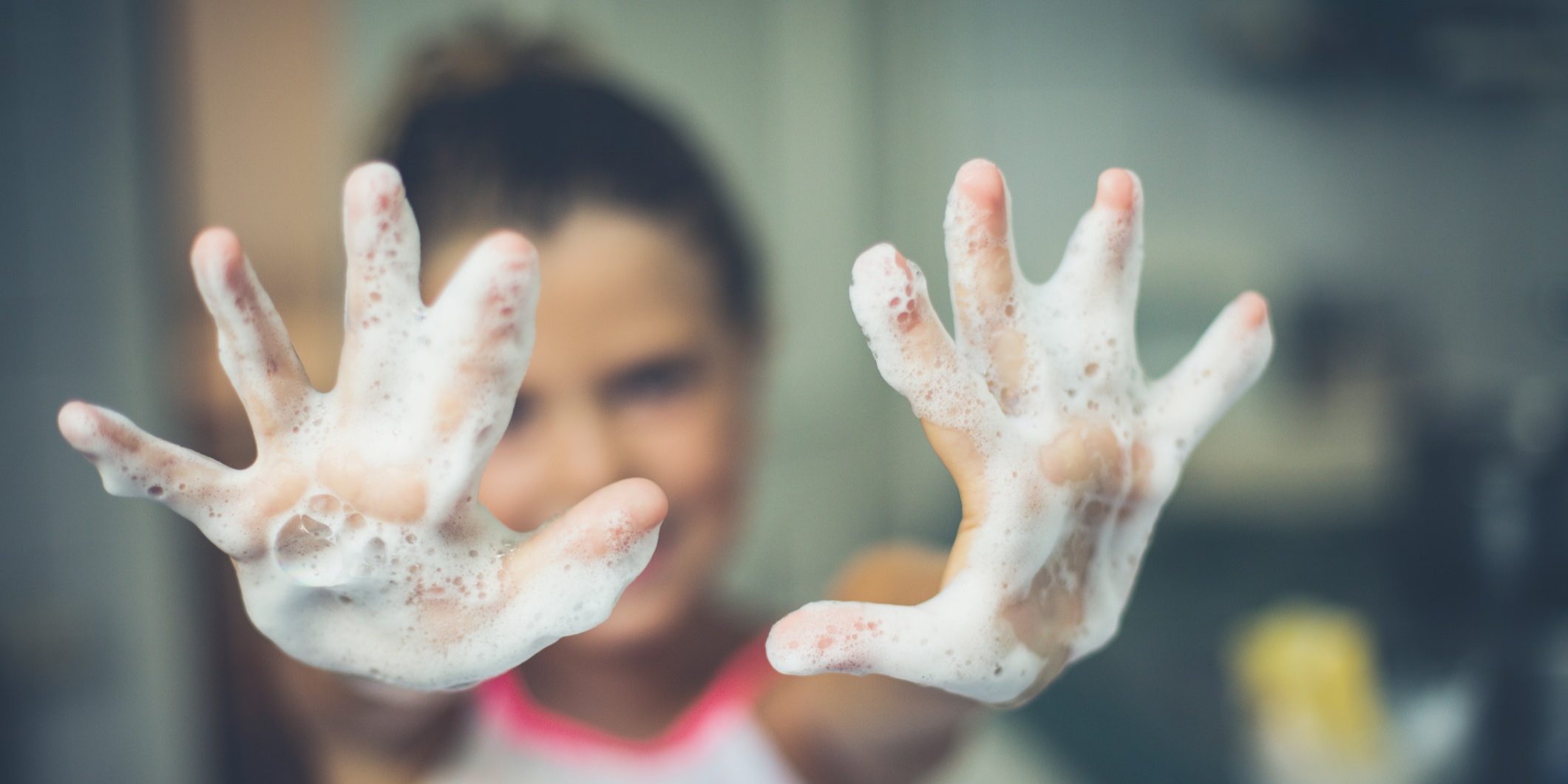 Hands of a little girl of foam. Close up. Copy space. Focus is on hands.