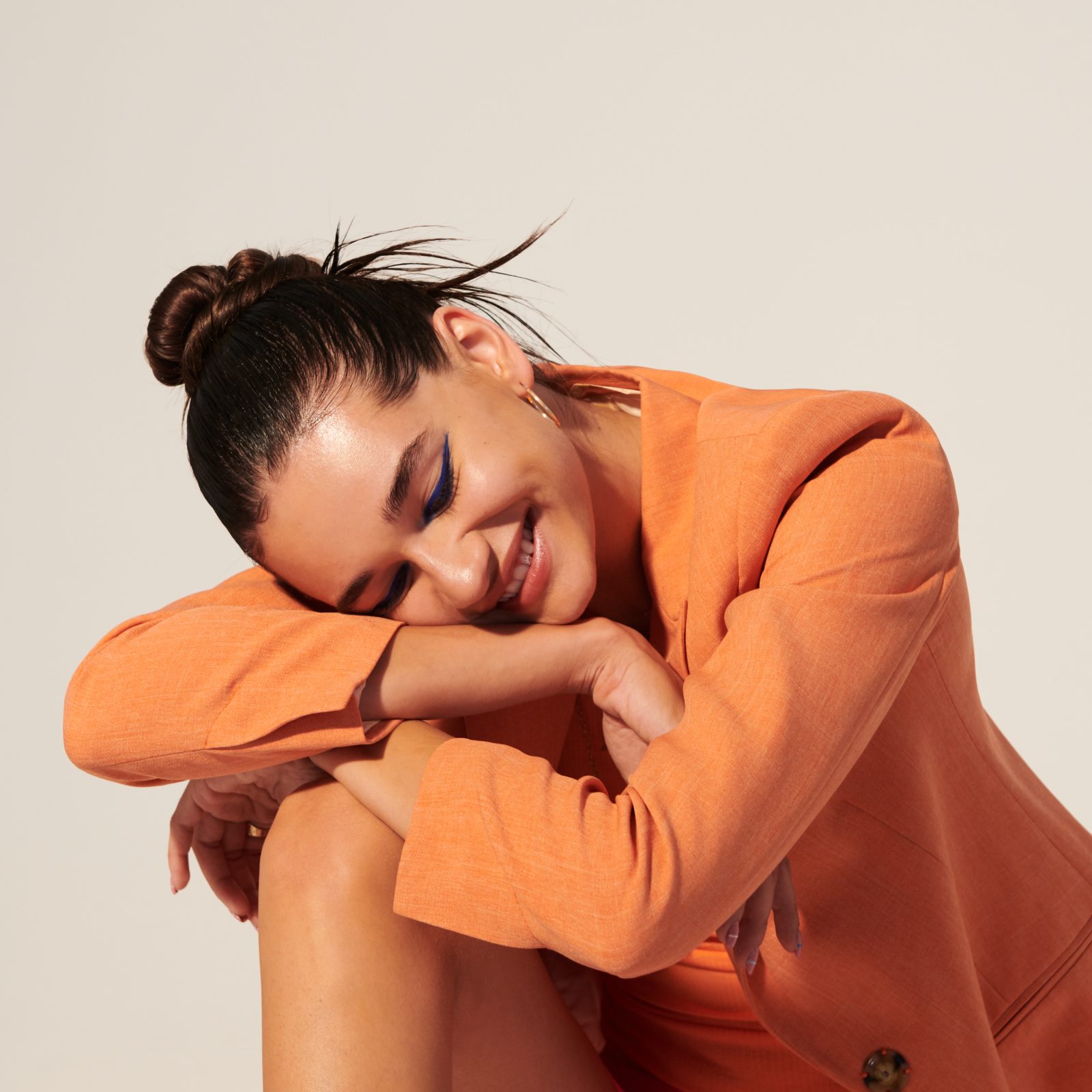 female resting her head on her knee and laughing