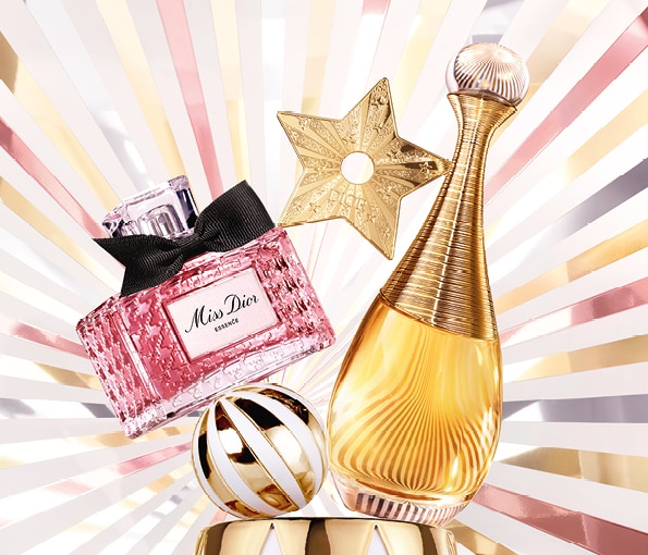 Flaconi di profumo Dior con decorazioni dorate e sfondo a raggi luminosi, atmosfera festiva ed elegante.