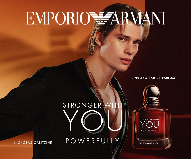 Emporio Armani Stronger With You Powerfully Eau de Parfum in flacone ambrato, presentato su sfondo caldo con figura stilizzata in primo piano.