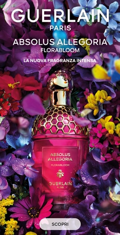 Guerlain Absolus Allegoria Florabloom, profumo con flacone rosa e tappo dorato, circondato da fiori colorati
