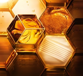 Texture ispirate al miele in forme esagonali dorate che richiamano l’iconica linea Guerlain Abeille Royale.