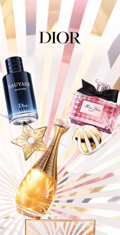 Flaconi di profumo Dior Sauvage, Miss Dior e J’Adore su sfondo a raggi luminosi con decorazioni dorate e argentate.