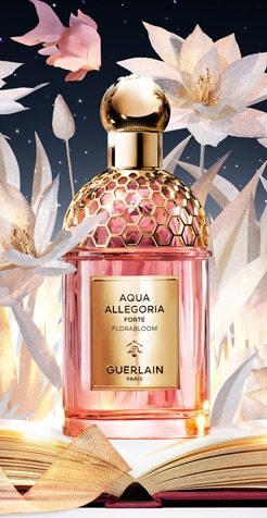 Flacone Guerlain Aqua Allegoria rosa e oro su sfondo floreale bianco con libro aperto.