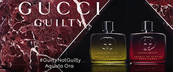 Due flaconi di profumo Gucci Guilty Absolu de Parfum Pour Homme e Pour Femme su sfondo marmo rosso, hashtag #GuiltyNotGuilty.