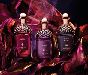 Boccetta del profumo Guerlain Absolus Allegoria Tabac Sahara tra foglie dorate, nuova fragranza intensa.