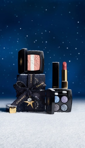 Chanel fragranze iconiche con flaconi N°5, Coco Mademoiselle e Bleu de Chanel su sfondo blu con dettagli neve.