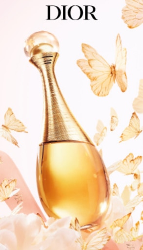 Flacone dorato del profumo Dior J’adore con farfalle decorative.