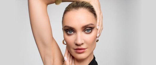 Bracciale dorato e top nero con spalline sottili su sfondo chiaro